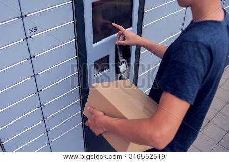 Client Using Automated Self Service Post Terminal Machine Or Locker To Deposit A Parcel For Storage