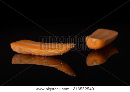 Group Of Two Halves Of Stale  Orange Stale Baby Carrot Baby Isolated On Black Glass