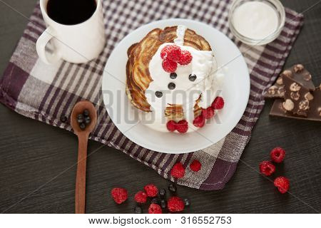 Tasty Pancakes With Blueberries And Raspberries On Cotton Towel On Dark Table, Cup Of Tea Or Coffe, 