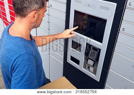 Client Using Automated Self Service Post Terminal Machine Or Locker To Deposit A Parcel For Storage