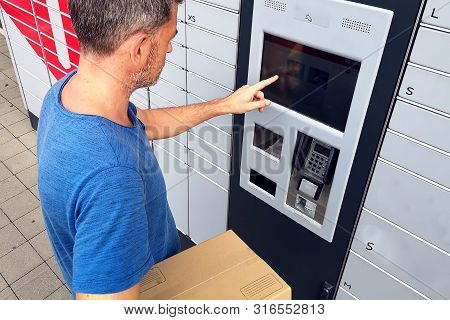 Client Using Automated Self Service Post Terminal Machine Or Locker To Deposit A Parcel For Storage