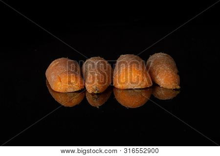 Group Of Four Halves Of Stale  Orange Stale Baby Carrot Baby Isolated On Black Glass