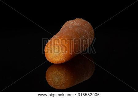 One Whole Stale  Orange Stale Baby Carrot Baby Isolated On Black Glass