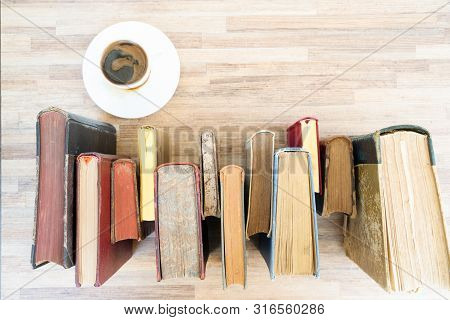 Books Row On Wooden Table With Cup Of Coffee, Top View Flat Lay. Reading, Learning, Literature Conce