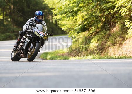 Blairsville, Ga / Usa - June 9:  A Man Riding A Motorcycle Leans Into A Turn At A High Rate Of Speed
