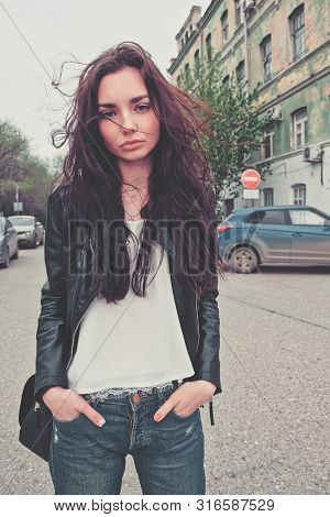 Sad Girl In Rip Jeans And Leaser Jacket Posing In The Center Of The Street Looking At Camera