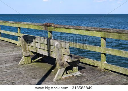 A Lone Bench On The Ocean View Fishing Pier In Norfolk, Virginia.