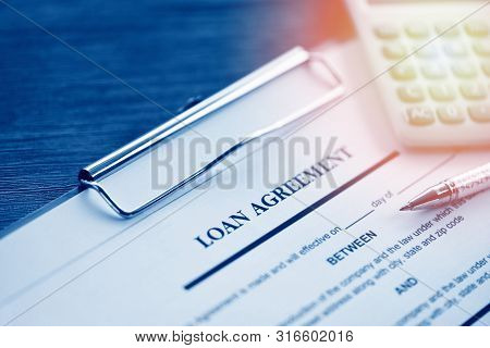 Loan Agreement Application Form With Pen And Calculator On Paper Financial Help / Financial Loan Neg