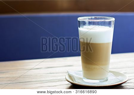 Latte Glass On The Table On The Terrace Of The Summer Cafe.  Hot Latte Glass On A Wooden Table.  Sun