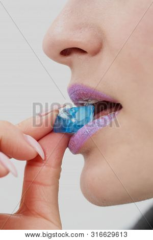 A Young Woman With Short Pixie Bob Haircut And Dyed Hair, Holds In The Mouth And In The Hands Gemsto