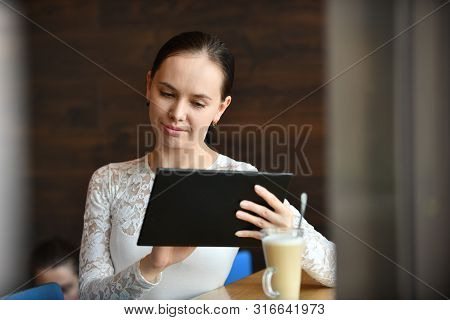 Young Happy Woman Working With Tablet Drinking Coffee, Sitting In Street Cafe