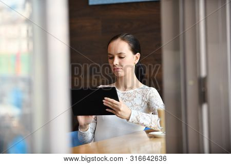 Young Happy Woman Working With Tablet Drinking Coffee, Sitting In Street Cafe