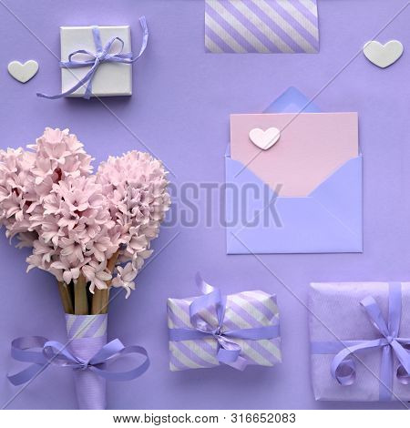 Purple Springtime  Background With Pink Hyacinth Flowers, Wrapped Gift Boxes And Decorative Hearts, 