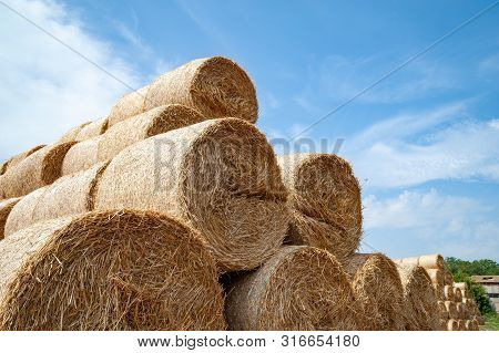 Close-up Of Hay Bales On A Sky Background. Hay Bales Are Stacked In Large Stacks.