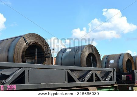 Rolled Steel Coil On On A Freight Train Fixed By A Chain. Import/export, Logistics Of The Heavy Carg