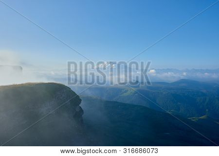 Elbrus At Sunrise, Fog And Clouds In The Foreground. Gum-bashi Pass, North Caucasus, Russia