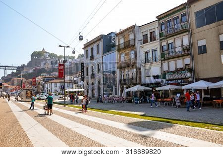 Porto, Portugal - August 31 2018: People Walking On Promenade By River Douro On A Sunny Day. The Emb