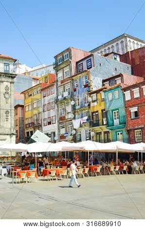 Porto, Portugal - August 31 2018: People On Promenade By River Douro On Sunny Day. The Embankment Is