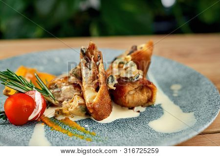 Selective Focus Of Toothsome Roasted Rolls With Cheese And Mushrooms Served With Tomatoes And Sauce 