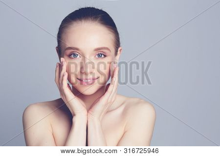 Portrait Of Beautiful Woman With Natural Make Up Touching Her Face.