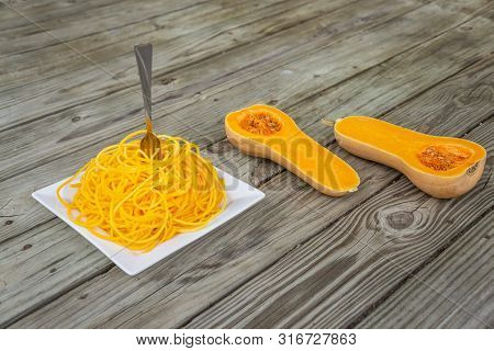 Butternut Squash Noodles With Fork Stuck In The Middle Of The Pasta.