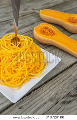 Butternut Squash Noodles With Fork Stuck In The Middle Of The Pasta.