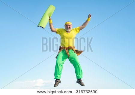 Funny Senior Man Jumping. Old Man Jumping On Blue Sky Background. Freedom Retirement Concept. Fit Se