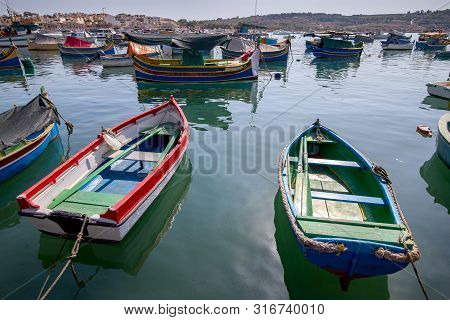 Traditional Fishing Boats Called Luzzu In The Bay Of The Village Marsaxlokk. Malta.