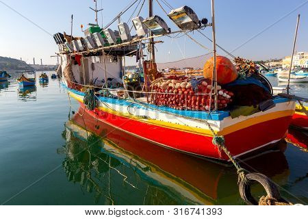 Traditional Fishing Boats Called Luzzu In The Bay Of The Village Marsaxlokk. Malta.