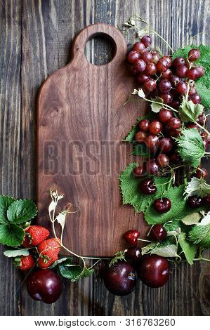 Beautiful Solid Walnut Cutting Board With Fresh, Red, Organic Homegrown Fruit. Plums, Grapes And Str