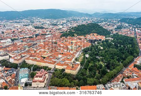 Aerial View Of Center City Graz From Helicopter Drone With Hill Schloßberg, Tower Uhrturm And Centra