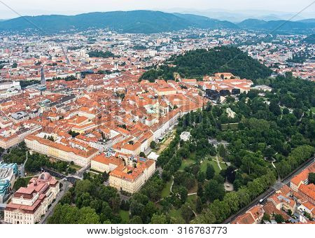 Aerial View Of Center City Graz From Helicopter Drone With Hill Schloßberg, Tower Uhrturm And Centra