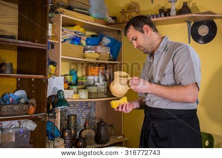 Professional Male Potter Preparing Ceramic Wares For Burning In Pottery Kiln With Milk - Old Russian