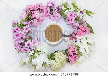 Colorful Flowers Of Pink Phlox, A Cup Of Coffee And Marshmallows On A Light Table, Top View, Flat La