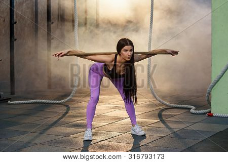 Beautiful Young Woman In Sports Uniform Doing Back Squat Cardio Exercises During Training At The Gym