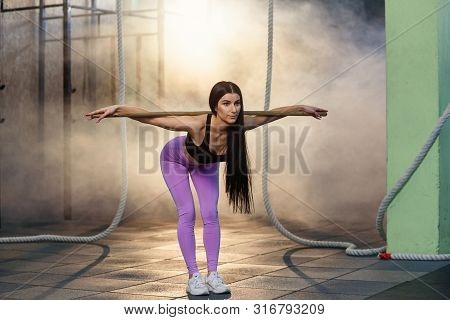 Beautiful Young Woman In Sports Uniform Doing Back Squat Cardio Exercises During Training At The Gym