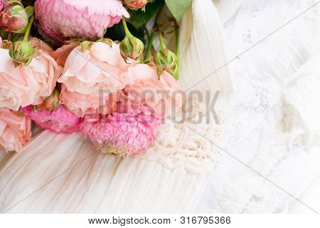 Female Dress And Jewellery With Fresh Rununculus Bouquet On White Dress