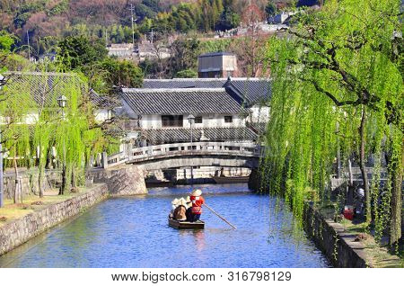 People in old-fashioned boat, Kurashiki canal in Bikan district, Kurashiki city, Japan
