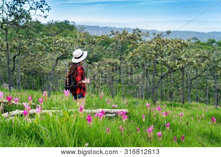 Woman Traveler With Backpack Enjoying At Krachiew Flower Field, Thailand. Travel Concept.