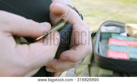 Mans Hands Loading A Pistol Magazine. Man Loads The Clip Of Pistol