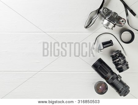 Retro Analog Film Camera With Lenses And Photography Equipment On White Wooden Table Background With