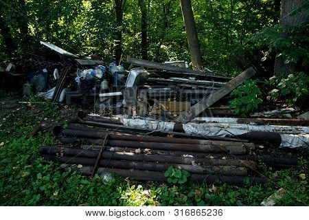 Inefficient waste from metal pipes, wooden boards, plastic bottles dumped in the forest