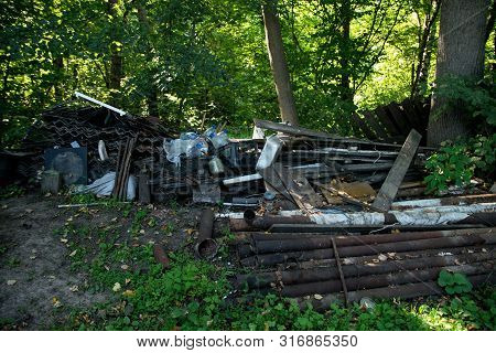 Inefficient waste from metal pipes, wooden boards, plastic bottles dumped in the forest