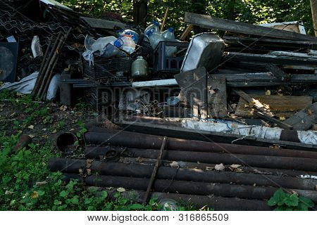 Inefficient waste from metal pipes, wooden boards, plastic bottles dumped in the forest