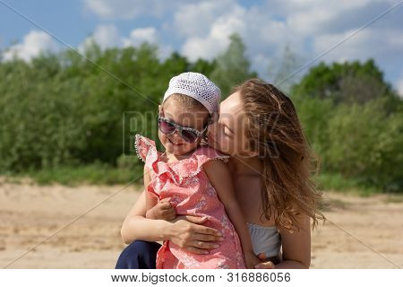 Young Woman Hugging A Child With Love And Tenderness