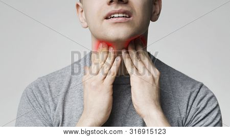 Breathing Problem. Young Man Pulping His Inflamed Neck, Close Up