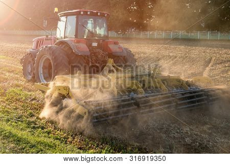 Tractor Cultivator Plows The Land, Prepares For Crops. Dust On Field