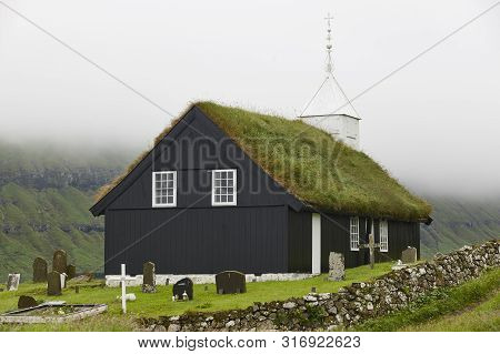 Traditional Turf Church In Faroe Islands On Foggy Day. Kaldbak
