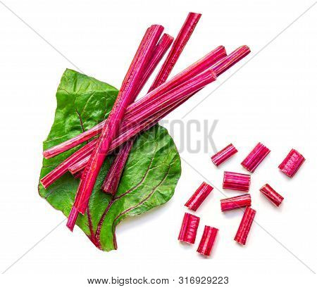 Creative Layout Made Of Fresh Rhubarb Or Rheum With Stalks, Leaves  And Pieces  Vegetable Isolated O