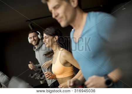 Young People Using Threadmill In Modern Gym